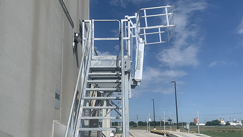 Access platform with drop gangway for unloading tank trucks at a chemical facility.