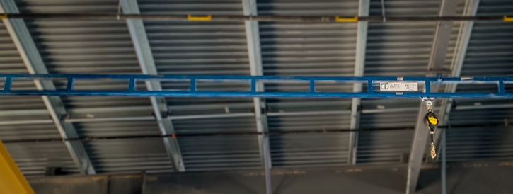 Gorbel Tether Track Rigid Rail Lifelines mounted to the ceiling above truck bays.