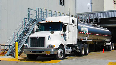 Truck loading access platform over tanker truck.